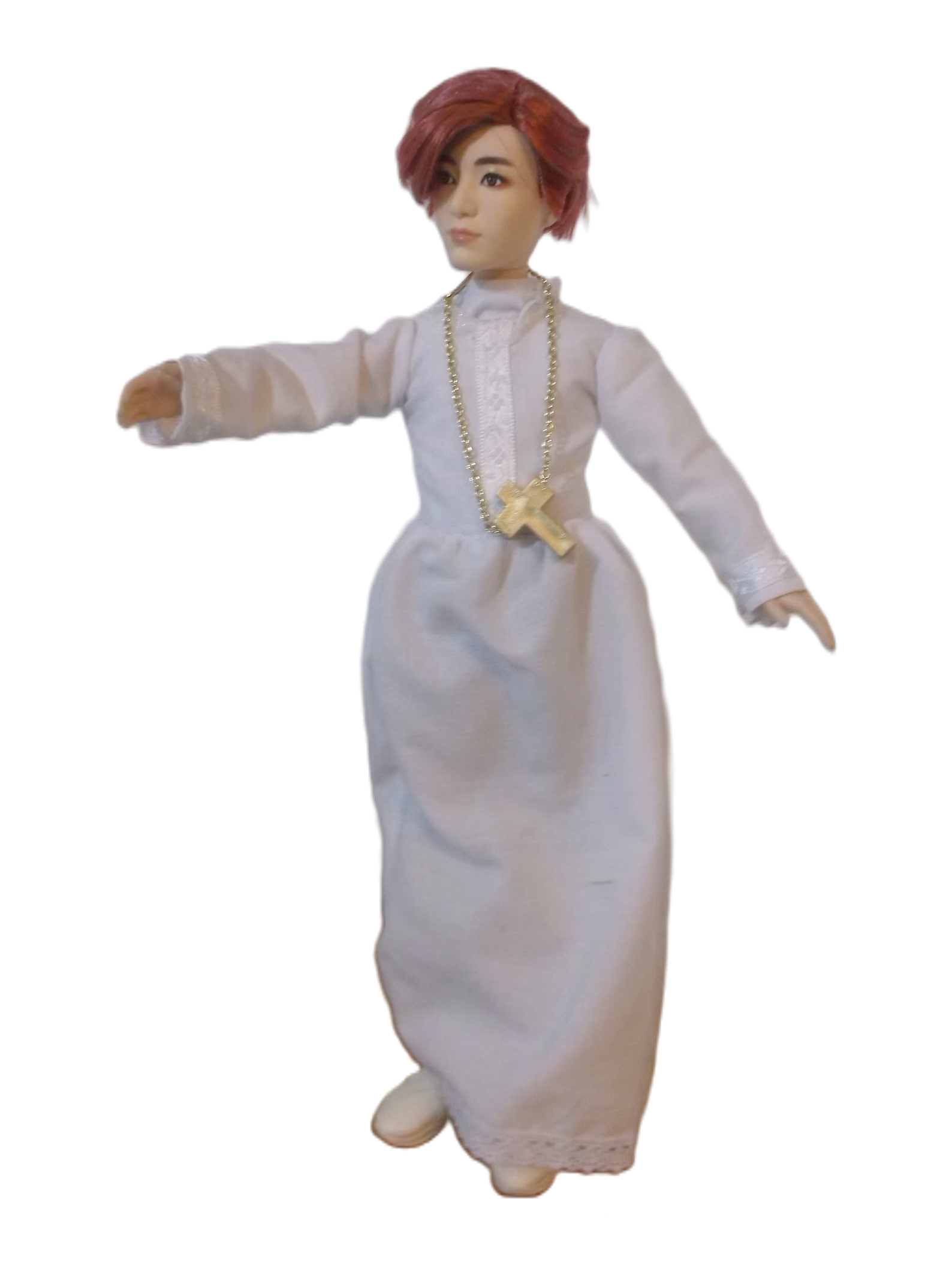 A photograph of a doll of Jeon Jungkook wearing the traditional vestments of a Catholic alter boy.